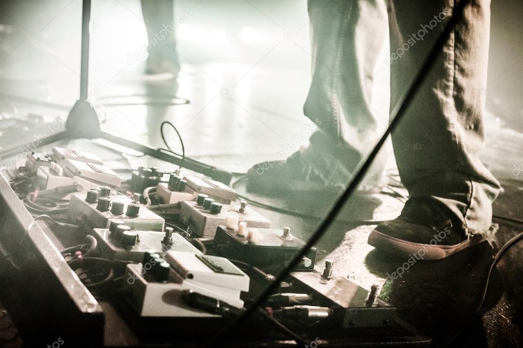 Electric guitar, small amp and pedals on a rug